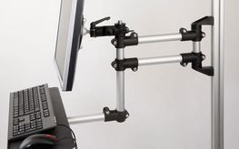 La photo montre un bras porteur complété par une tablette pour clavier et un support pour écran